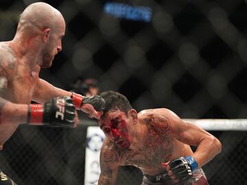 Alexander Volkanovski (red gloves) and Max Holloway (blue gloves) fight at UFC 276 at T-Mobile Arena.